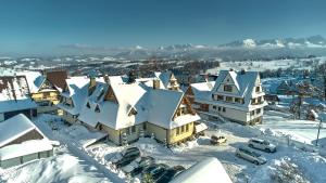 una ciudad cubierta de nieve con casas y coches en Pokoje Gościnne Stoch, en Ząb