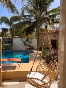 a swinging chair in front of a swimming pool at Francesca Guest House in Dakar