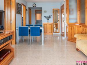 a dining room with a table and blue chairs at Carabela 1º3ª in Sant Feliu de Guíxols