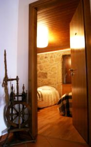 um quarto com uma porta que leva a um quarto com uma cama em Cantinho Santiago em Belmonte