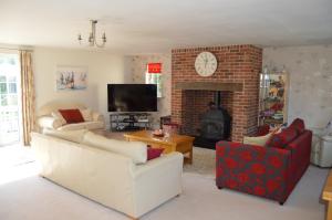 a living room with two couches and a fireplace at Everlong Farm in Diss