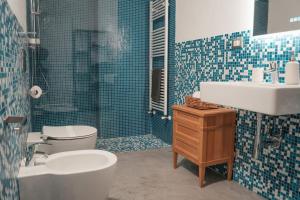 a bathroom with a toilet and a sink and a shower at Recinto Nobili 4 - private parking vista cortile in Asti +17 photos