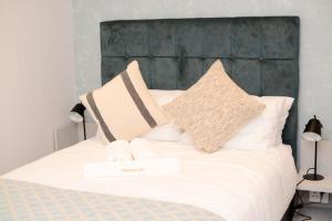 uma cama branca com duas almofadas em cima em Precious Paradise Zimbali Blvd em Ballito