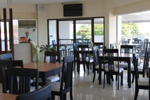 Sumo Asia Hotels - Davao في مدينة دافاو: غرفة طعام مليئة بالطاولات والكراسي