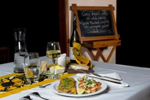 Chefe Chume的住宿－Dunes de Dovela eco-lodge，一张桌子,上面放着一盘食物和一瓶葡萄酒