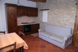 cocina con sofá y mesa en Agriturismo Sant'Antonio, en Montegridolfo