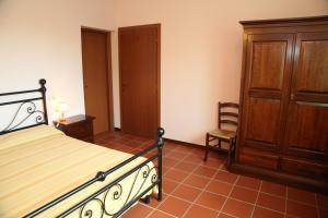 モンテグリドルフォにあるAgriturismo Sant'Antonioのベッドルーム1室(ベッド1台付)、木製キャビネットが備わります。