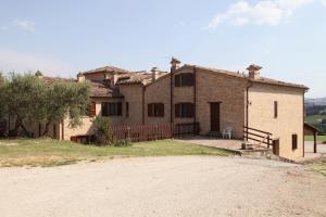 una gran casa de ladrillo con una entrada delante de ella en Agriturismo Sant'Antonio en Montegridolfo