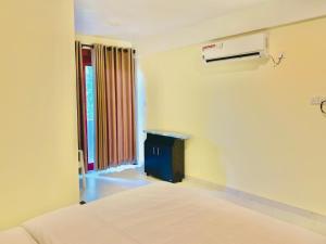 ein weißes Zimmer mit einem Bett und einem Fenster in der Unterkunft Hotel EliteInn Mahiyanganaya in Mahiyangana
