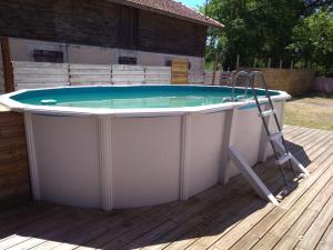 a hot tub on a deck with a ladder at Maison privée avec piscine in Pontenx-les-Forges