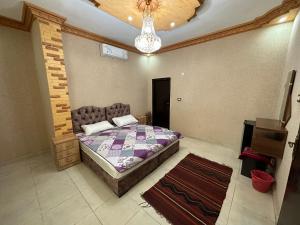 Schlafzimmer mit einem Bett und einem Kronleuchter in der Unterkunft Petra View Flat in Wadi Musa