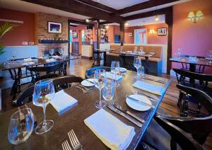 a dining room with tables and chairs and wine glasses at The Kings Head in Dorking