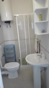 La salle de bains blanche est pourvue de toilettes et d'un lavabo. dans l'établissement La finestra sul mare, à Castellammare del Golfo
