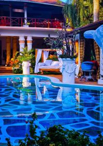 una piscina de agua azul en un complejo en African House Resort en Malindi