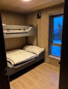 a small room with two bunk beds and a window at Ski in/ski out i Aurdal - helt ny hytte in Aurdal