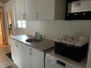 a kitchen with a sink and a basket of towels at Dejlig lejlighed in Svinninge