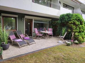 a patio with chairs and a table in a yard at Timmendorf - Strandnah in Timmendorfer Strand