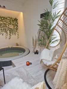 une salle de bains avec une baignoire jacuzzi et une chaise dans l'établissement La Love Story, à Hastière-par-delà