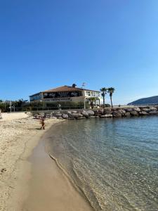 a beach with a building in the background and the ocean at Marinca du Port de Toulon in Toulon