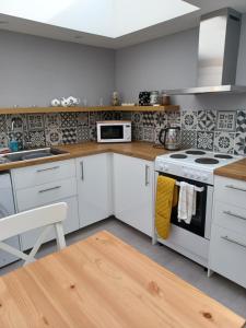 a kitchen with white cabinets and a stove top oven at The Toolshed in Daliburgh