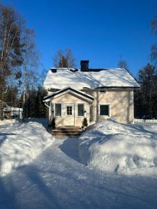 ein schneebedecktes Haus mit einem Stapel Schnee in der Unterkunft Villa Juuris in Rovaniemi