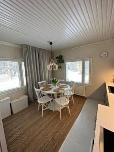 eine Küche und ein Esszimmer mit einem Tisch und Stühlen in der Unterkunft Villa Juuris in Rovaniemi