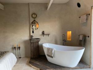 een badkamer met een groot wit bad en een bed bij The Meetinn in Waverveen