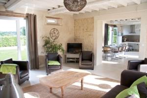 salon ze stolikiem kawowym i krzesłami w obiekcie Maison Bel'Air Bayeux w mieście Vaucelles