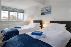 two beds sitting next to each other in a bedroom at Crannog Cottage in Llandudno