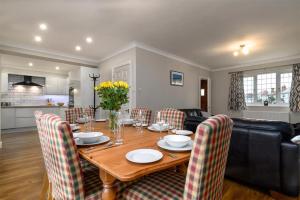 a living room with a wooden table and chairs at Crannog Cottage in Llandudno