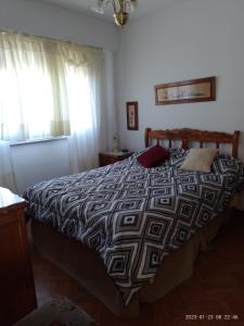 um quarto com uma cama com um edredão preto e branco em Departamento frente al Mar. em Mar del Plata