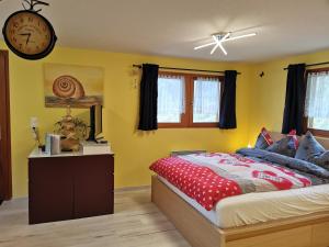 una camera da letto con un letto e un orologio a parete di Studio mit traumhafter Aussicht a Ritzingen
