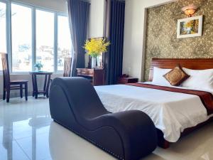 Queen Garden Hotel & Apartment في فنغ تاو: غرفة نوم بسرير كبير مع كرسي ازرق