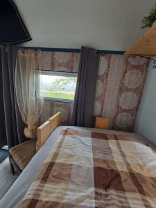 ein Schlafzimmer mit einem Bett und einem Fenster in einem Zimmer in der Unterkunft GeraldineWeg30- Bauwagenflair in Hessisch Oldendorf