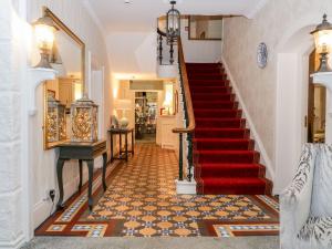 a hallway with a staircase with a red carpet at Valley View in Dalton in Furness