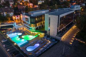 Vrnjačka Banja的住宿－Hotel Tonanti，一座建筑,在晚上前方有一个游泳池