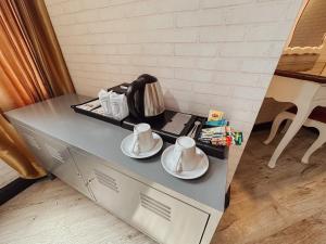 une table avec deux tasses et des assiettes dessus dans l'établissement Hotel De Khuvieng, à Chiang Mai