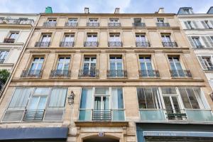 un grand bâtiment avec de nombreuses fenêtres donnant sur une rue dans l'établissement 05 - Parisian Design Loft, à Paris