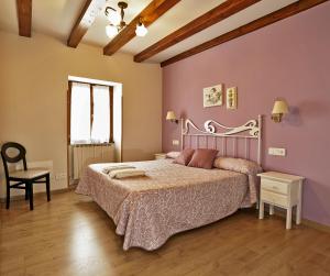 a bedroom with a large bed with pink walls at Hostal Orialde in Ochagavía