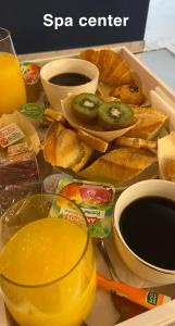 a table with a box of food and a glass of juice at Hôtel Center Saint-Quentin in Saint-Quentin