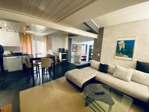 ein Wohnzimmer mit einem weißen Sofa und einem Tisch in der Unterkunft Super appart piscine proche Genève in Viry