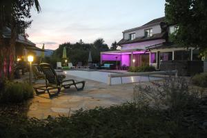 a house with a patio and a swimming pool at night at Super appart piscine proche Genève in Viry