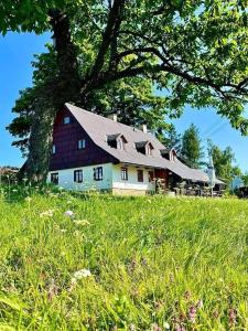 een grote schuur bovenop een weelderig groen veld bij Chalupa u kapličky Říčky v Orlických horách in Wüstenei