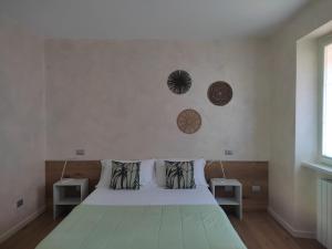 1 dormitorio con 1 cama con 2 mesitas de noche y una ventana en IseoLakeRental - La Filandina, en Riva di Solto