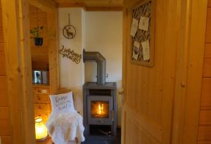a wood burning stove in a room with a door at Chalet Bergliebe Turrach in Turracher Hohe