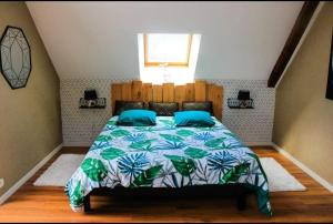 Schlafzimmer mit einem Bett mit einer blauen und grünen Tagesdecke in der Unterkunft Gite correze spa jaccuzi massage in Saint-Germain-les-Vergnes