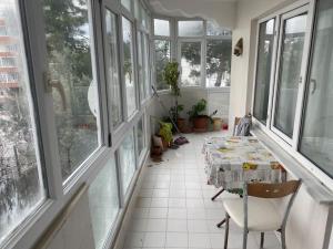 a room with a table and chairs and windows at Apartmen in Mudanya in Mudanya