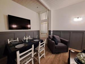 - un salon avec une table à manger et un canapé dans l'établissement Villa des Thermes, St Jean d'Angély, à Saint-Jean-dʼAngély