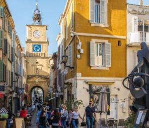 a group of people walking down a street with a clock tower at *L'indiana*Hyper Centre*Fibre Wifi* in Salon-de-Provence