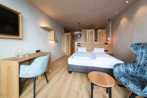 una camera d'albergo con letto, scrivania e sedie di Hotel-Garni Ehrenfels a Scena